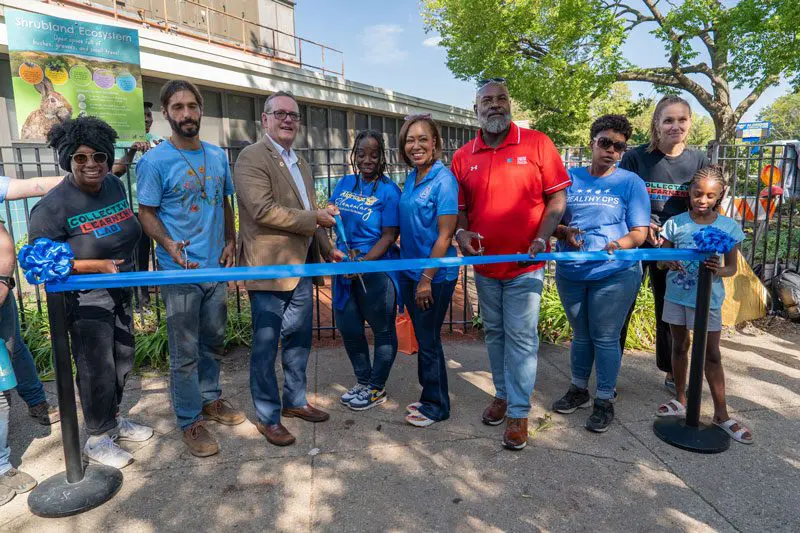 A photo of Students and Young Professionals Community (SYPC) doing a ribbon cutting ceremony at the WEF Community Service Project