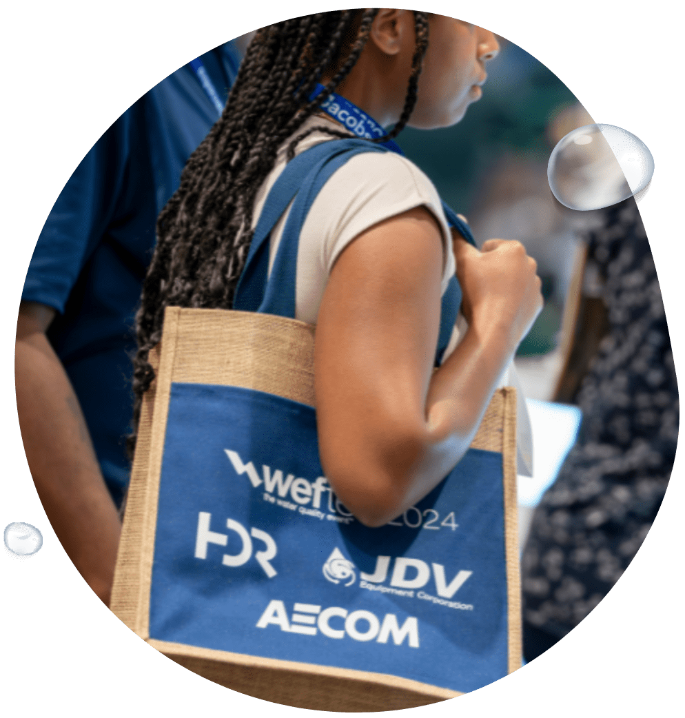 Image of woman holding swag bag with WEFTEC sponsor logos